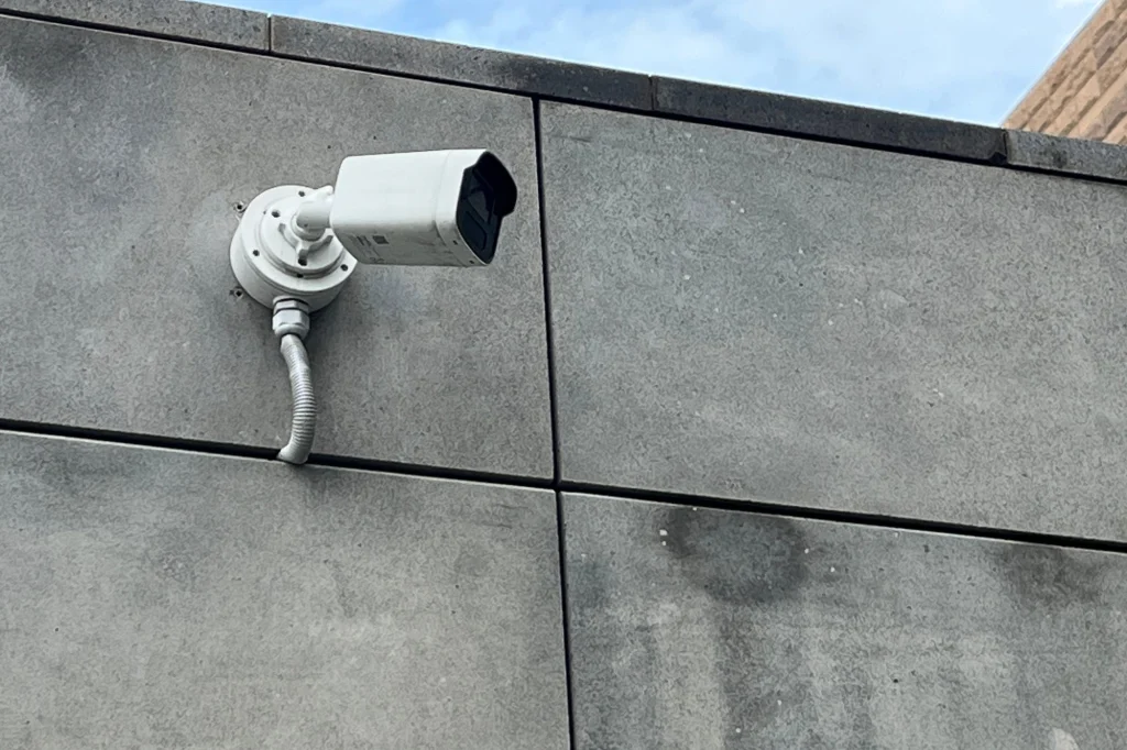 Câmera de segurança instalada na parede externa de concreto de um prédio