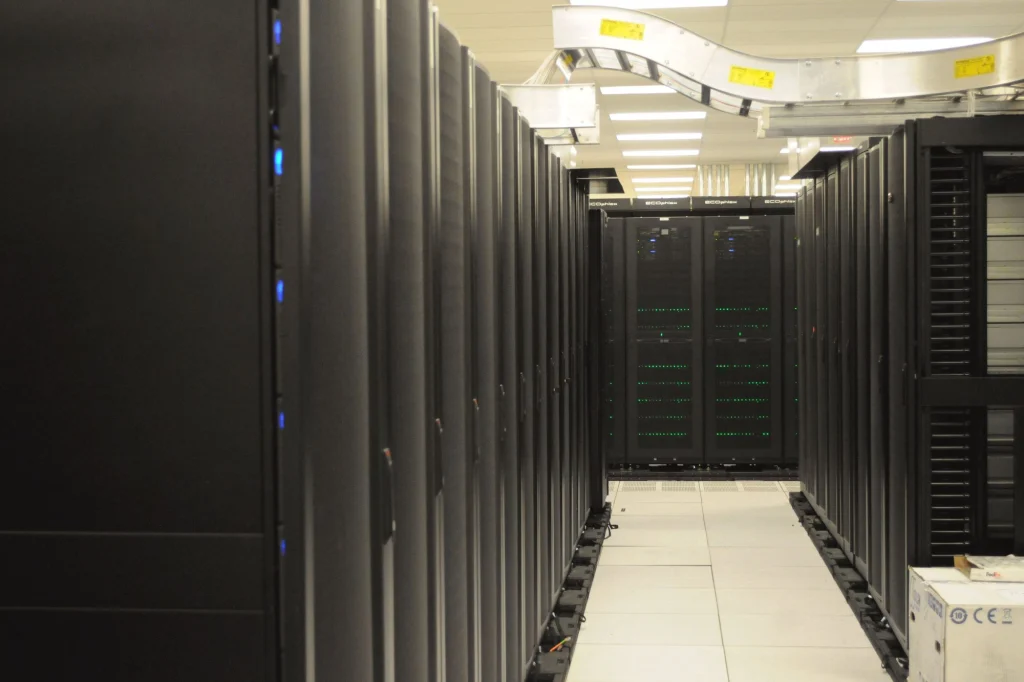 Corredor entre fileiras de racks de servidores em uma sala de dados